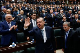 Turkey’s Prime Minister Tayyip Erdogan greets his supporters as he arrives at a meeting at the Turkish parliament in Ankara